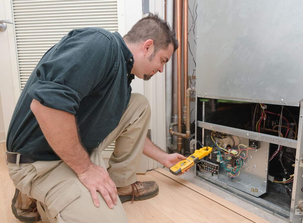 Technician servicing furnace in Hillsdale home.
