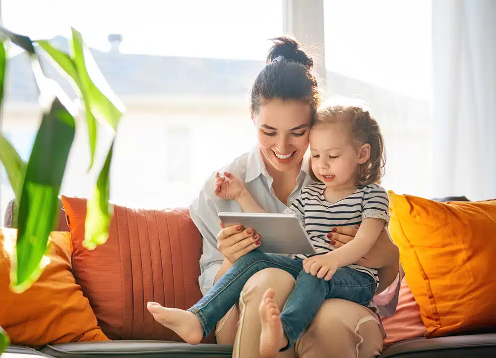 A mother and daughter reading off of an ipad